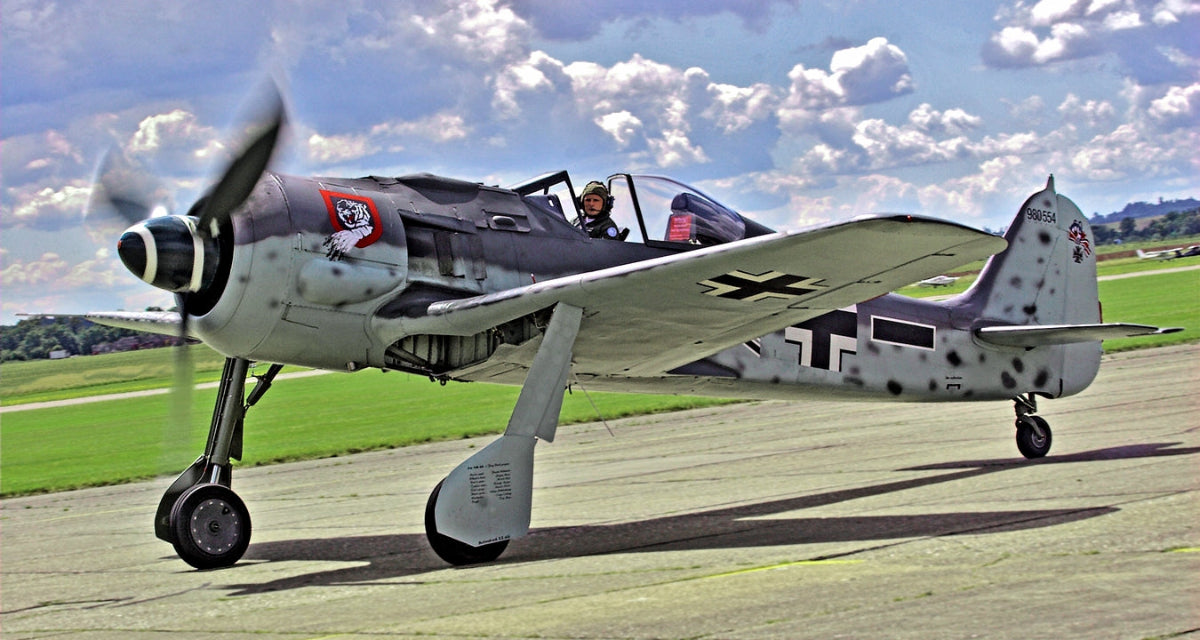 Vintage military airplane on a runway with a clear sky background