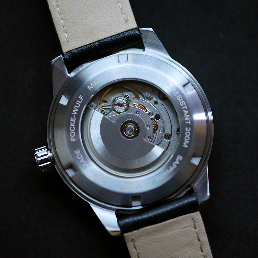 Watch back cover with brand name on a dark background