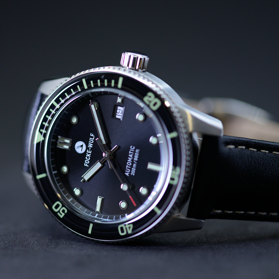 Watch with black dial and green accents on a dark background